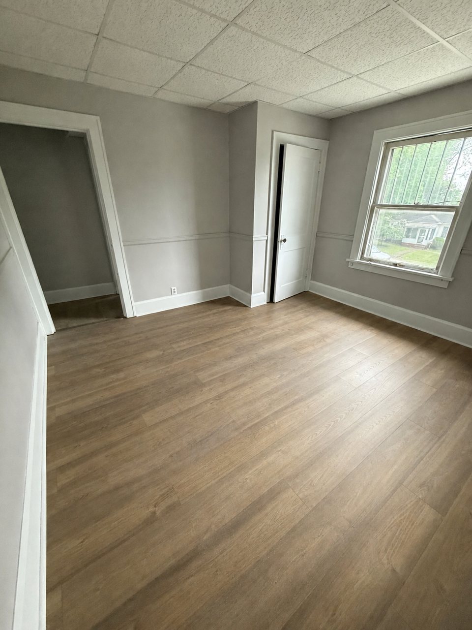 Finished bedroom with pale wood flooring