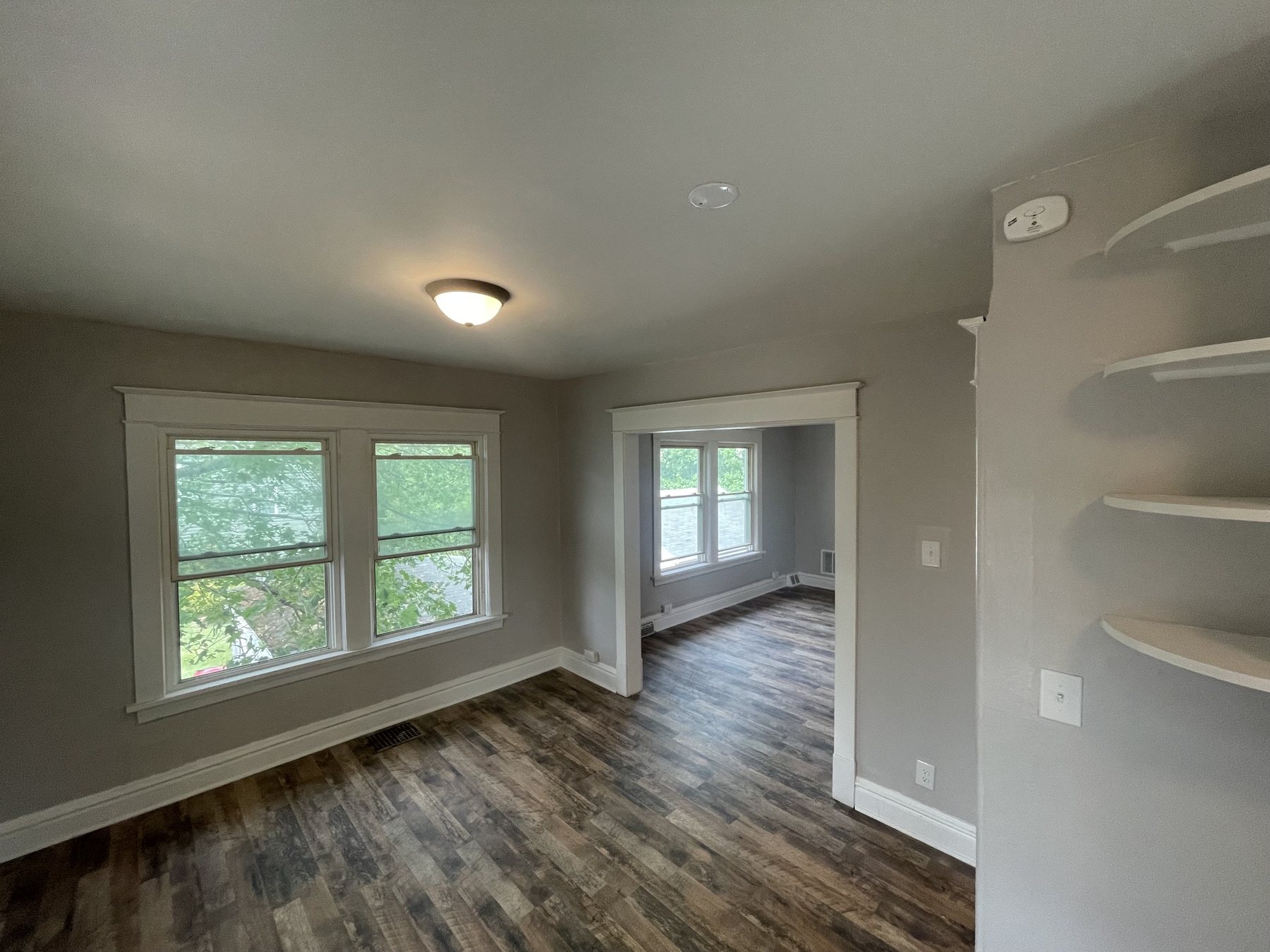 Finished living room with warm flooring and built-in shelves